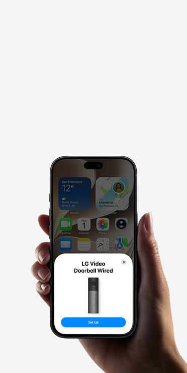 A hand holding an iPhone showing the Home app with a smart home accessory setup prompt