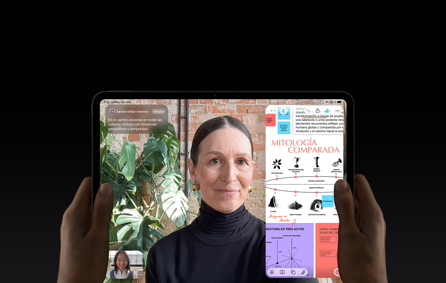 iPad Pro, parte delantera exterior, color negro espacial, las manos izquierda y derecha de una persona sujetándolo en horizontal, esquinas redondeadas, marco de la pantalla negro, la pantalla muestra una conversación de FaceTime traducida en tiempo real y una app educativa con una presentación sobre mitología comparada con texto, diagramas y notas escritas a mano