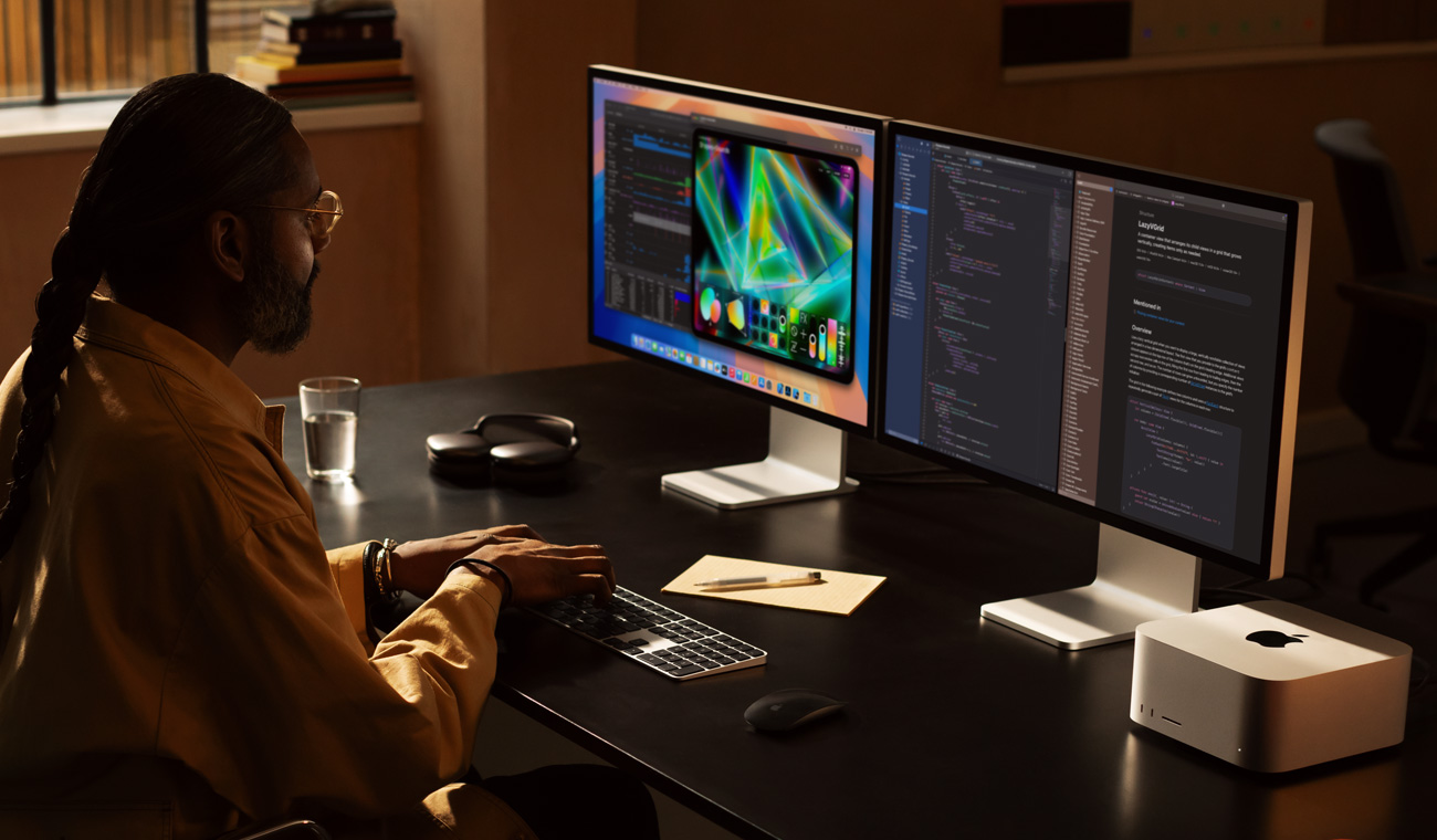 Egy professzionális felhasználó Mac Studión és két Studio Display monitoron dolgozik
