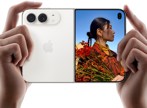 „iPhone Duo“, žvaigždžių baltos spalvos, horizontalioje padėtyje, atlenktas, kairiajame skydelyje matomos 48 MP „Dual Fusion“ galinės kameros, dešiniajame skydelyje matomas žmogus, kurio nuotrauka daroma iš išorinio ekrano, fotografuojamas asmuo gali matyti savo veidą, kol daroma nuotrauka naudojant „Duo Preview“