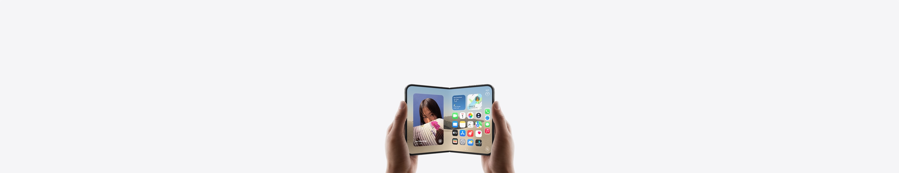 iPhone Duo, kuru divas rokas tur horizontālā novietojumā, atvērts, iekšējā displejā redzams sākumekrāns