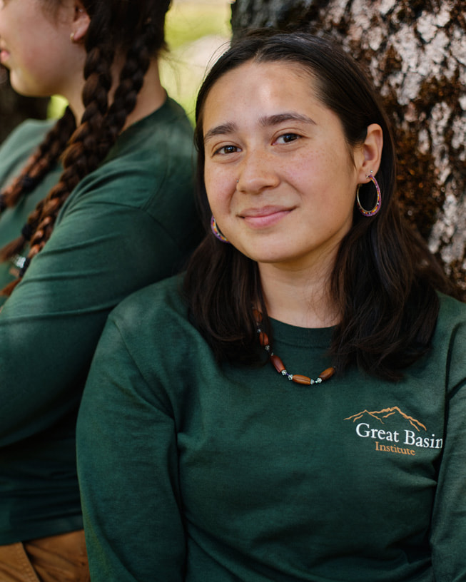 Nicole Long wears a Great Basin Institute shirt and poses in front of a tree.