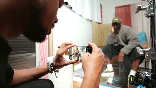 Una toma detrás de escena de Karston Tannis haciendo un retrato del diseñador Ade Okuboyejo. Imagen tomada con un iPhone 16 Pro Max.