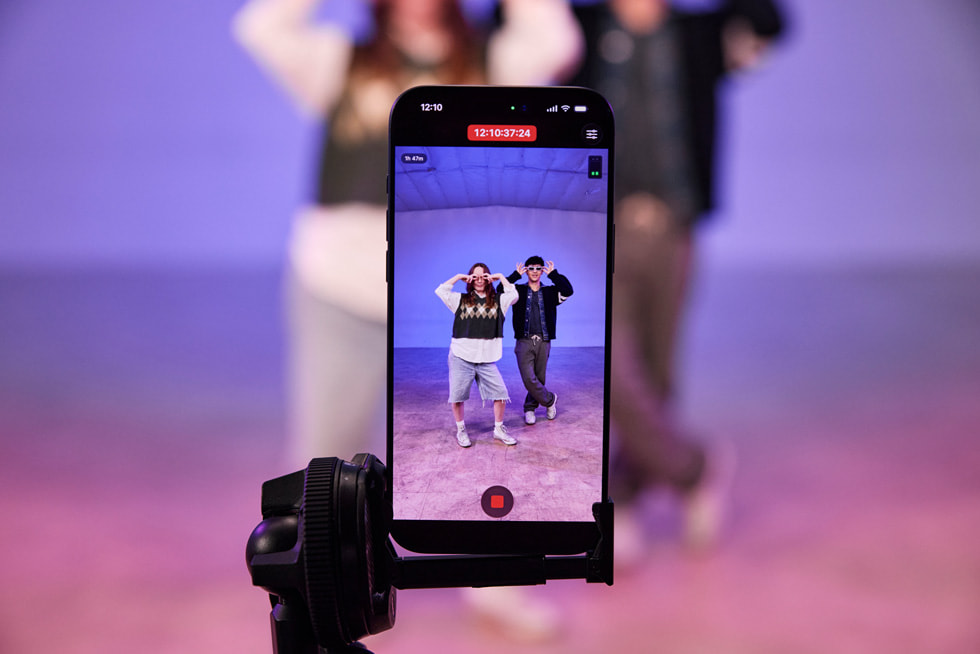 Eine Nahaufnahme eines iPhone 17 Pro Max auf einem Stativ zeigt eine Live-Aufnahme von Kyle Hanagami und einem:r Tänzer:in, die in einem Studio ihre Moves vorführen.