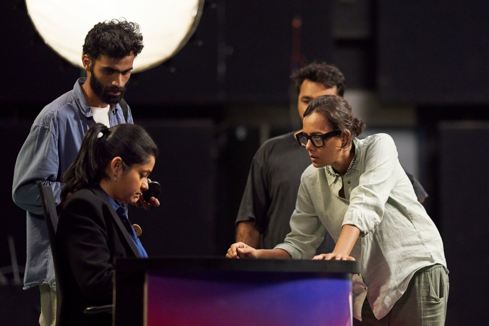 No set, Dhritisree Sarkar e sua equipe discutem uma cena com uma atriz.
