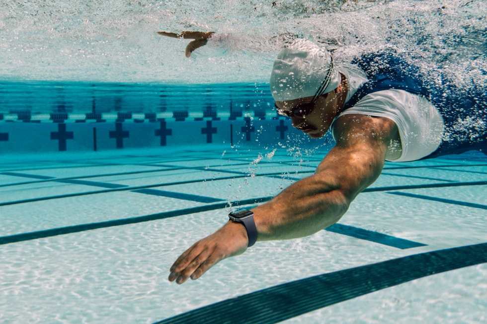 Une personne portant une Apple Watch Series 12 nage dans une piscine. 