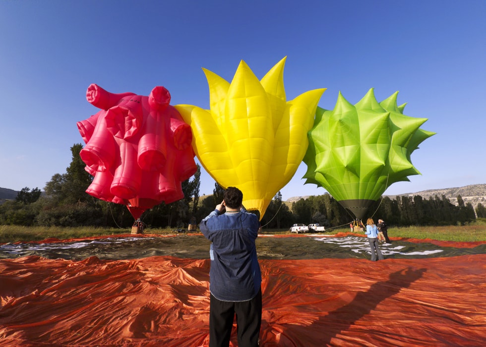 Bünyamin Aydın is pictured standing in front of three hot-air balloons.