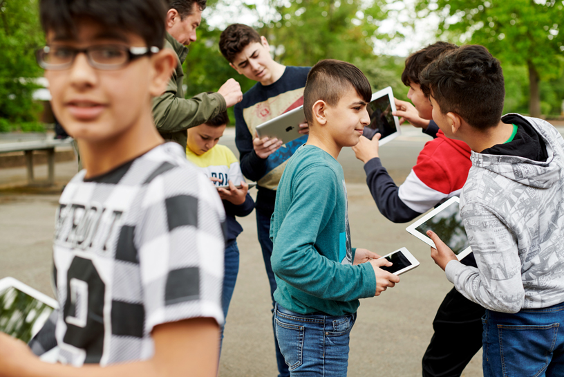 外でiPadを持つ生徒。
