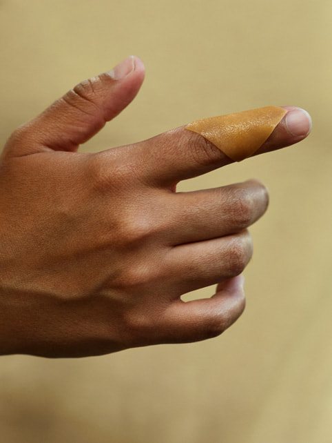SweetBio’s APIS honey wound care pliable sheet on an index finger.