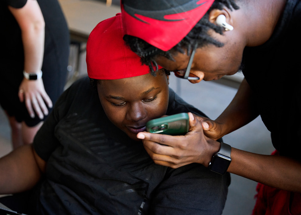 Glen-David Hardy-Covington and John Johnson look at an iPhone screen.