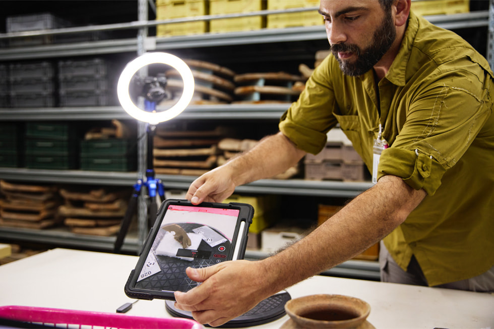 Dr. Badillo hält ein iPad Pro in verschiedenen Winkeln über eine Maske in einem Büro.
