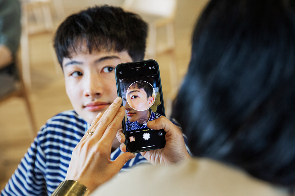Ein:e Apple Freiwillige:r bei der Unterstützung des Creative Studios Programm in Tokio mit einem iPhone.
