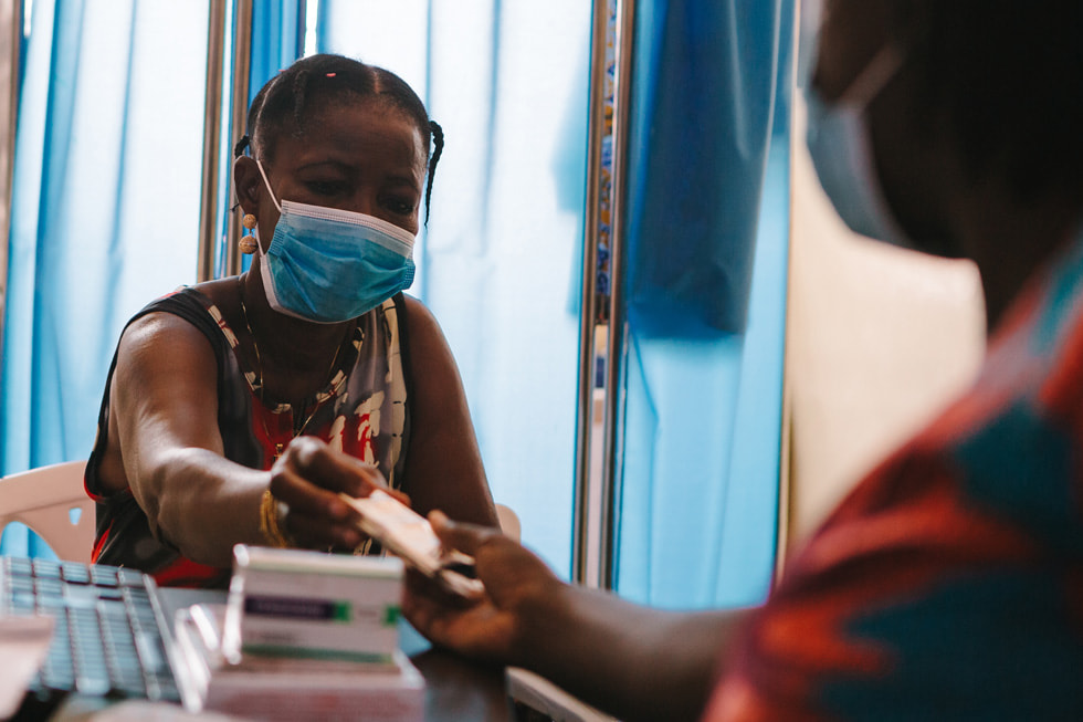 En kvindelig patient får sin medicin til antiretroviral behandling fra St. Martin de Porres Hospital.