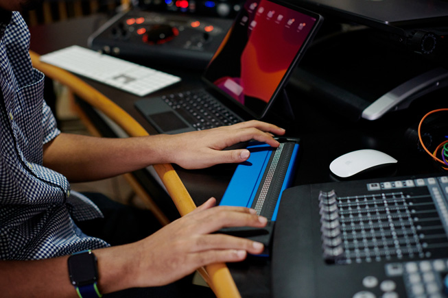 Nahaufnahme von Matthew Whitakers Händen bei der Verwendung einer Braille-Tastatur zum Arrangieren von Musik.
