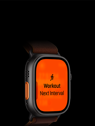 Apple Watch Ultra 4, kryt z titánu v čiernej farbe, tréning Beh, ďalší interval, pohľad zvonku na ľavú stranu, oranžové akčné tlačidlo, alpská slučka