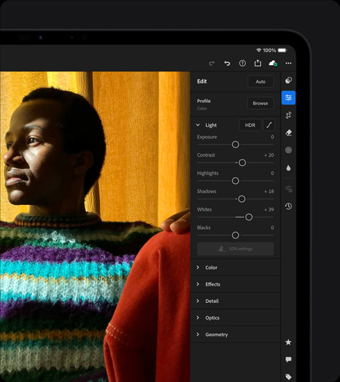 iPad Pro, front exterior, landscape orientation, space black colour, display showing a photograph being edited of a person in a colourful jumper, tools and effects menu open at right