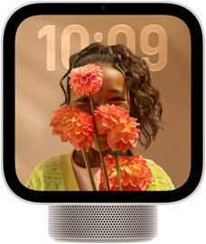 Apple HomeView, starlight colour (pale gold), screen shows semi-transparent time of day over a wallpaper of a person holding flowers