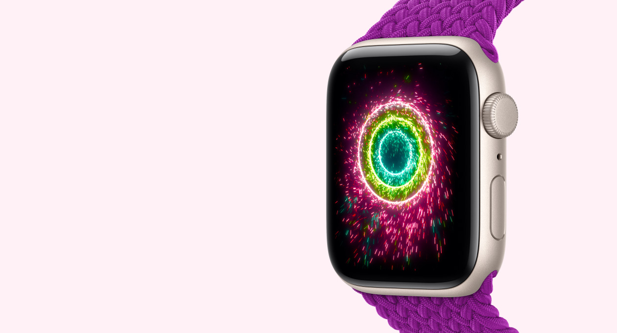 Apple Watch SE 3, cassa in alluminio galassia con cinturino Solo Loop intrecciato magenta, il display mostra gli anelli Attività con motivi simili a stelle filanti; anelli concentrici rosa, verde lime e blu chiaro