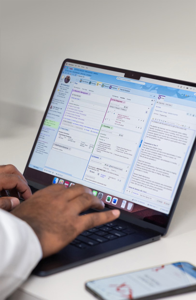 En sundhedsmedarbejder tjekker elektroniske patientjournaler på en MacBook Pro.