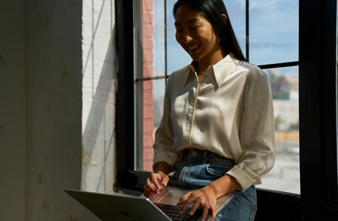 Nhân viên tại Apple Store đứng cạnh khách hàng, cả hai đang tương tác với MacBook.